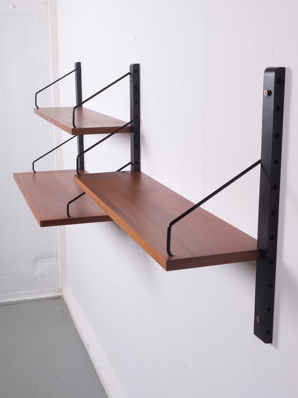 Modulaire wandkast, Royal system, geproduceerd door Cado in de jaren 50. Dit teak houten systeem heeft 3 planken met 3 rails